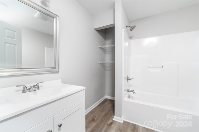 bathroom featuring vanity, hardwood / wood-style floors, and washtub / shower combination