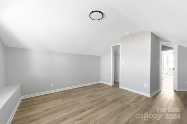 bonus room with wood-type flooring and lofted ceiling