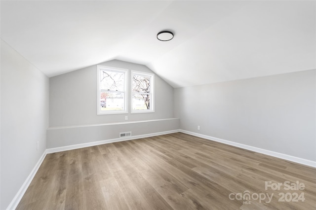 additional living space featuring lofted ceiling and hardwood / wood-style floors