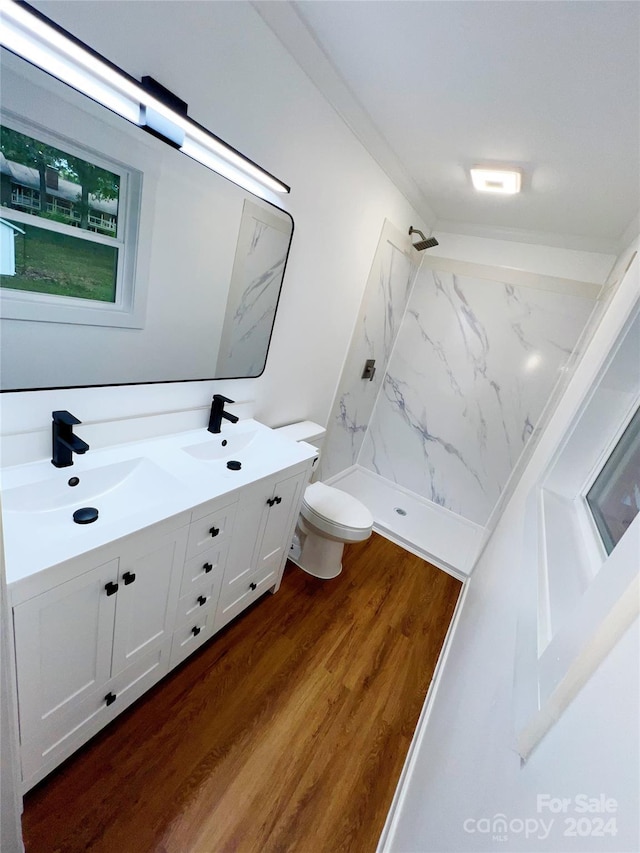 bathroom with hardwood / wood-style floors, vanity, toilet, and walk in shower