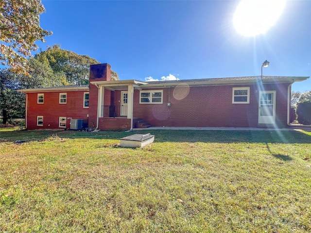 rear view of house featuring a yard and central AC unit