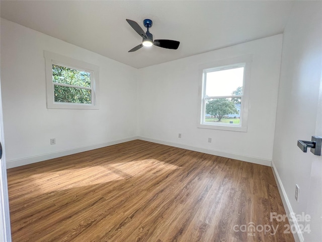 unfurnished room featuring ceiling fan, plenty of natural light, and wood-type flooring