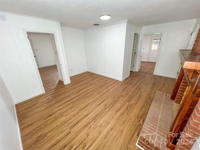 unfurnished room featuring light hardwood / wood-style floors and a textured ceiling