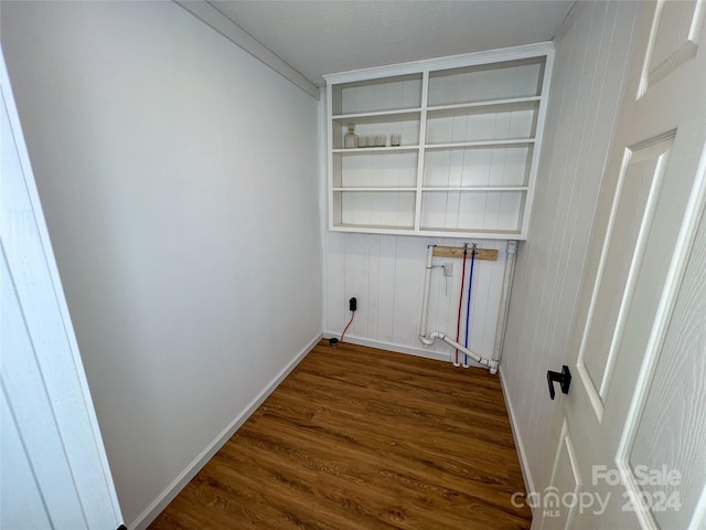 laundry area with dark wood-type flooring and ornamental molding