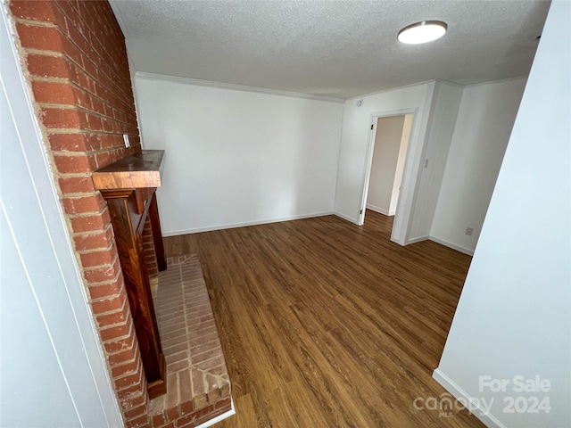 unfurnished living room with a textured ceiling and hardwood / wood-style flooring