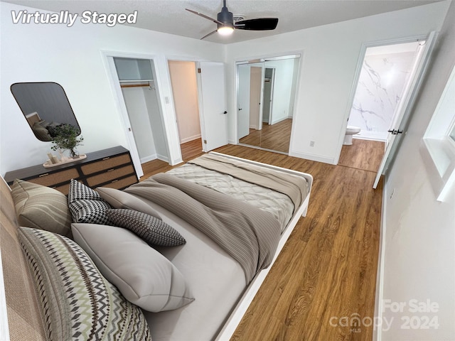 bedroom with hardwood / wood-style floors, ceiling fan, and ensuite bath