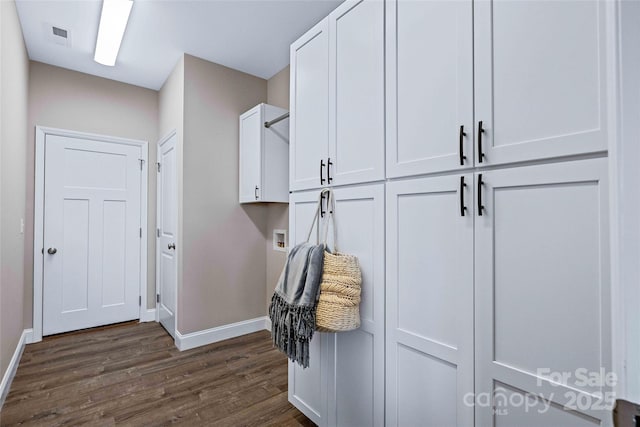 mudroom featuring dark wood-type flooring, visible vents, and baseboards