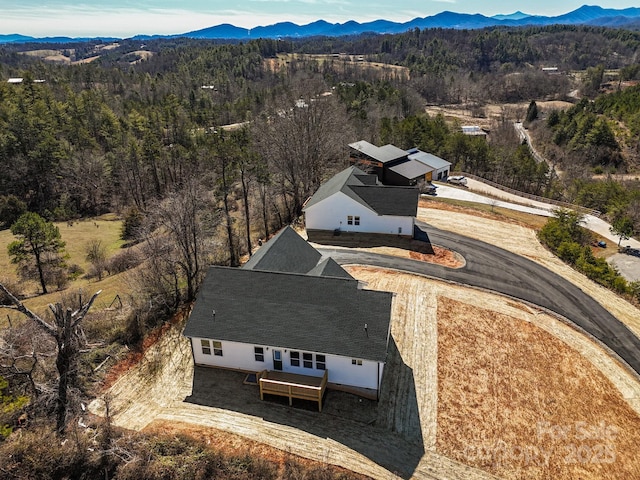 drone / aerial view with a forest view and a mountain view