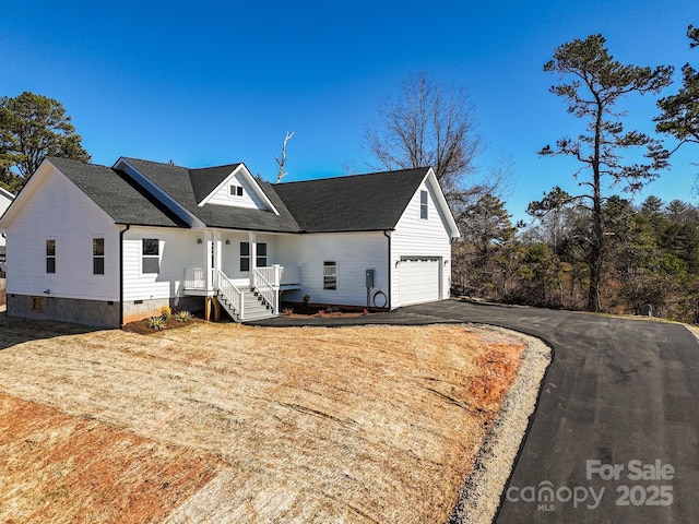 view of front facade with crawl space, a garage, and aphalt driveway