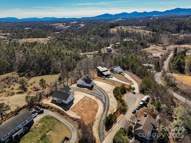 drone / aerial view with a mountain view and a view of trees