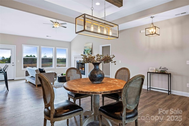 dining room featuring baseboards, visible vents, a ceiling fan, dark wood-style flooring, and vaulted ceiling with beams