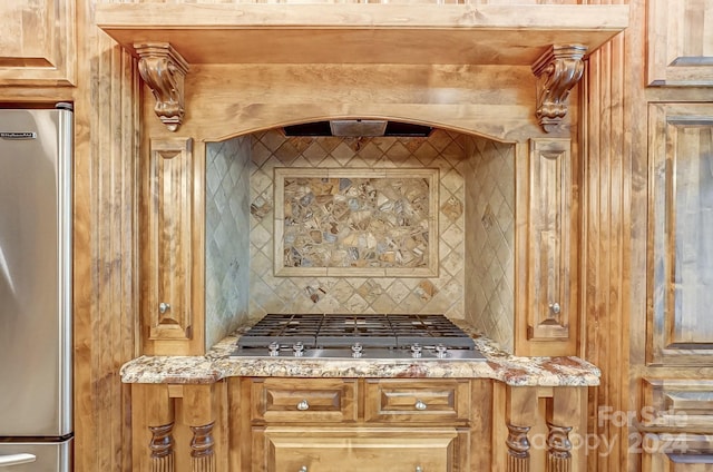 kitchen with light stone counters, stainless steel appliances, and decorative backsplash