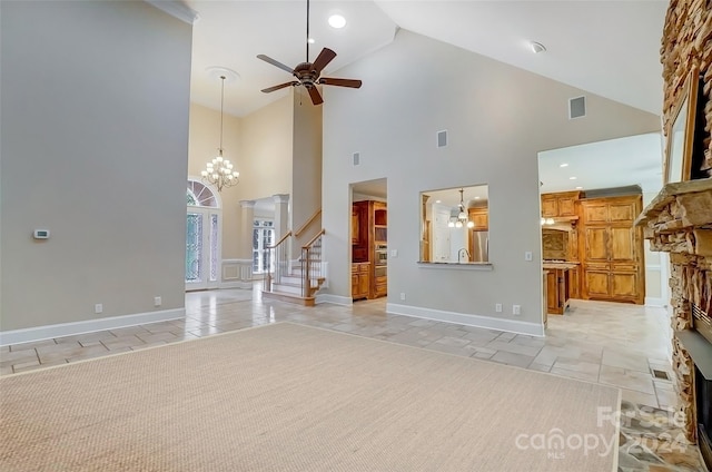 unfurnished living room featuring a fireplace, ceiling fan with notable chandelier, high vaulted ceiling, and light tile patterned floors