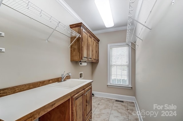 laundry room featuring hookup for a washing machine, hookup for an electric dryer, sink, cabinets, and ornamental molding