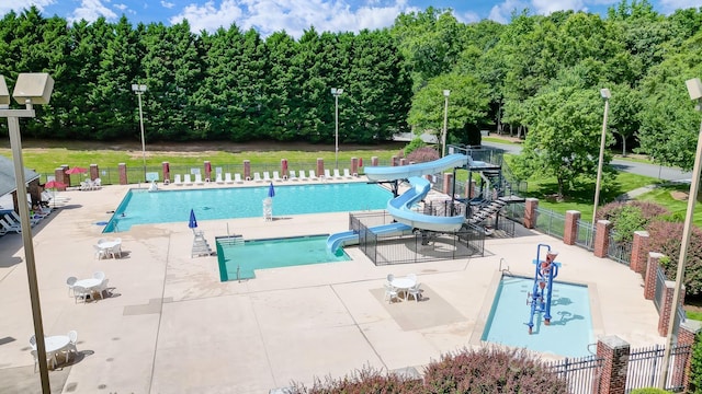 view of pool with a patio, a yard, and a water slide