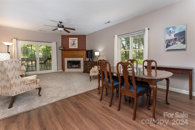 dining space featuring a wealth of natural light, a fireplace, ceiling fan, and hardwood / wood-style flooring