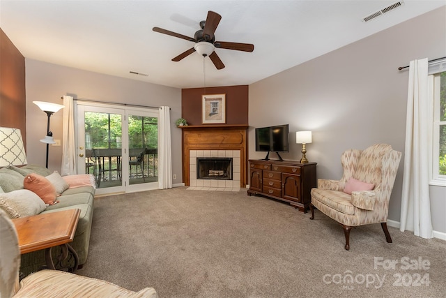 living room with carpet, ceiling fan, and a fireplace