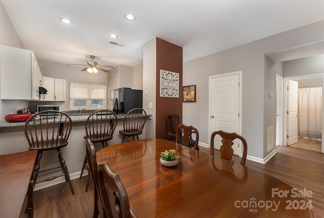 dining area with ceiling fan and dark hardwood / wood-style flooring