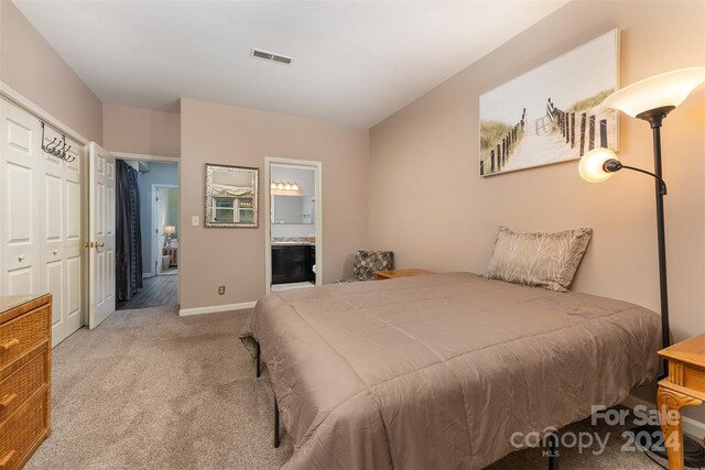 carpeted bedroom with connected bathroom and a closet