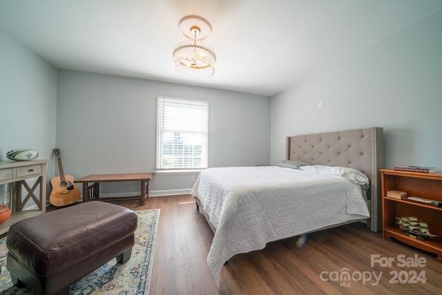 bedroom featuring an inviting chandelier and dark hardwood / wood-style floors