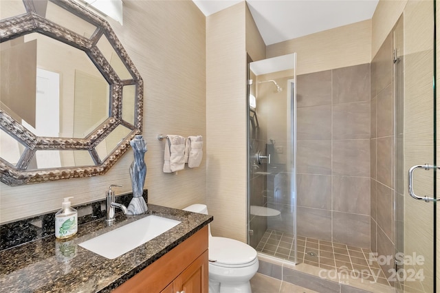 bathroom with vanity, toilet, a shower with door, and tile patterned floors