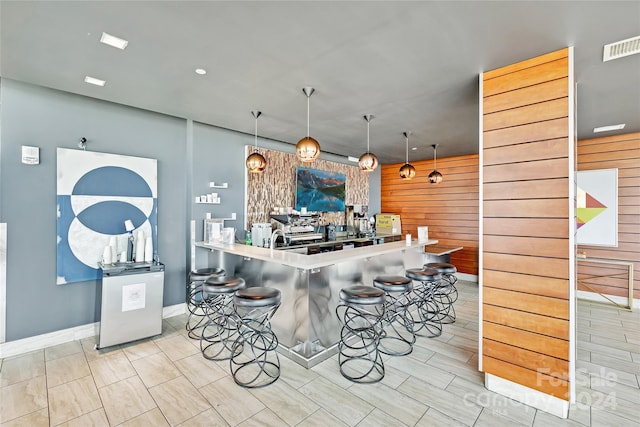 215 N Pine St Unit 3705, Charlotte, NC 28202 - kitchen featuring a kitchen bar, baseboards, pendant lighting, and wood walls