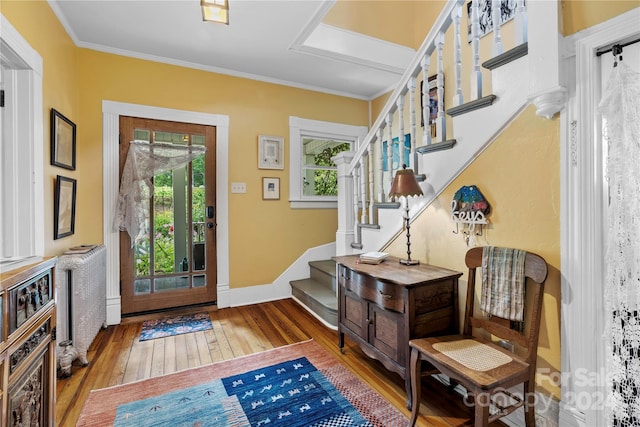 entryway featuring hardwood / wood-style flooring and ornamental molding