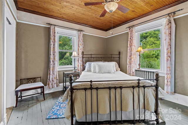 bedroom with hardwood / wood-style flooring, multiple windows, and ceiling fan