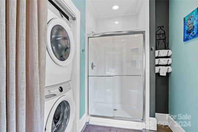 clothes washing area with crown molding and stacked washer and clothes dryer