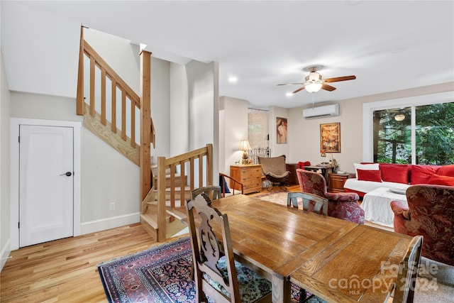 dining space featuring an AC wall unit, light hardwood / wood-style floors, and ceiling fan