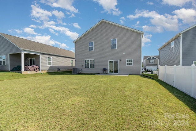 rear view of property featuring a lawn, a patio, and central air condition unit