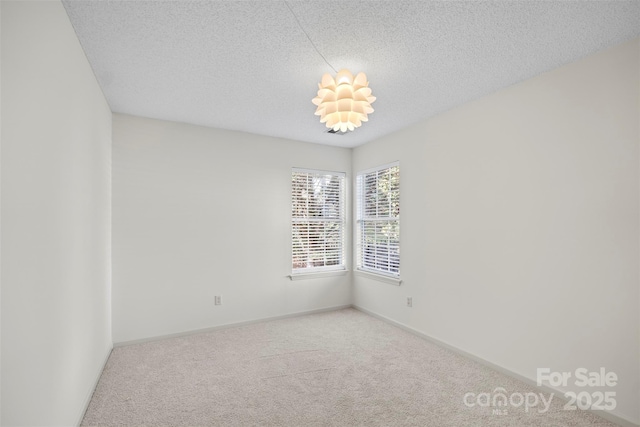 carpeted empty room featuring a textured ceiling