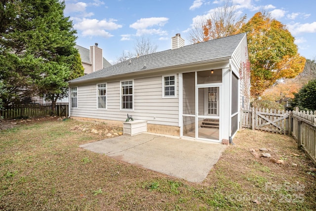 rear view of house featuring a patio, a sunroom, and a lawn