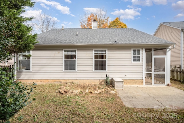 rear view of house featuring a yard, a patio area, and a sunroom