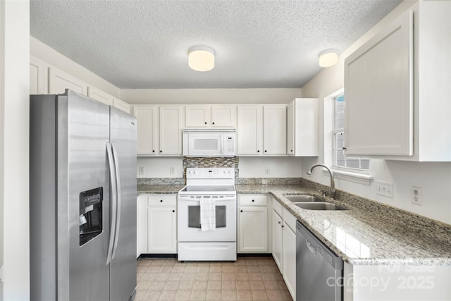 kitchen with white cabinetry, sink, stainless steel appliances, light stone countertops, and a textured ceiling