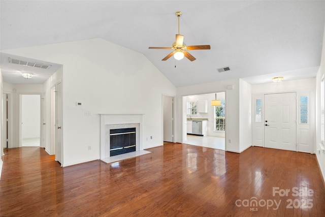 unfurnished living room with dark hardwood / wood-style floors, ceiling fan, a fireplace, and high vaulted ceiling