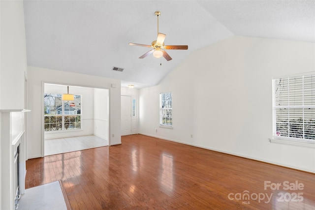 unfurnished living room with hardwood / wood-style flooring, ceiling fan, and high vaulted ceiling