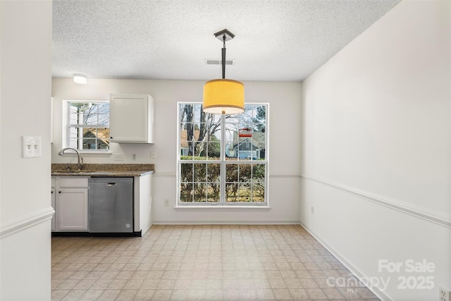 kitchen featuring white cabinetry, hanging light fixtures, sink, and dishwasher