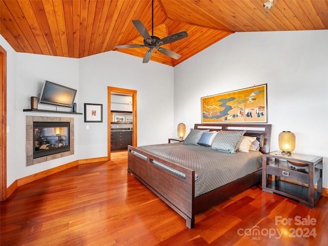 bedroom with wood ceiling, a fireplace, lofted ceiling, ceiling fan, and hardwood / wood-style floors