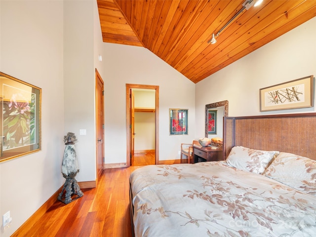 bedroom with track lighting, a closet, a spacious closet, wooden ceiling, and light wood-type flooring