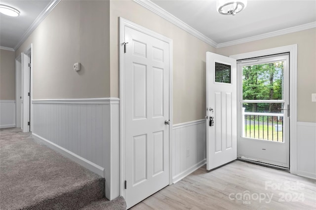 entryway with light hardwood / wood-style floors and crown molding