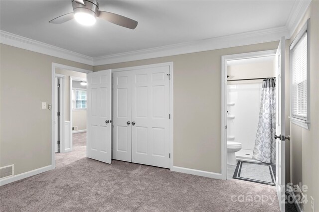 unfurnished bedroom featuring ornamental molding, light carpet, ceiling fan, and a closet