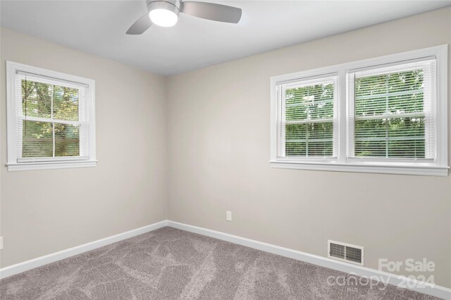 empty room with ceiling fan and carpet floors