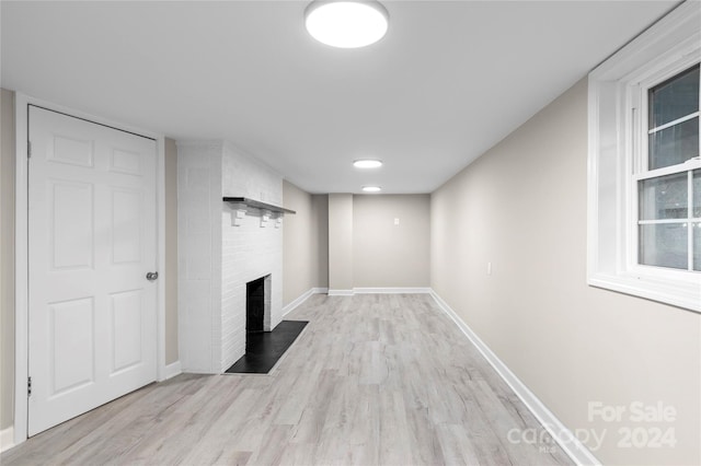 unfurnished living room featuring a fireplace and light hardwood / wood-style floors