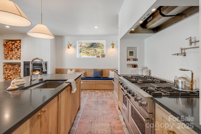 22 Kenilwood Pl, Asheville, NC 28803 - kitchen with range with two ovens, a sink, dark countertops, wall chimney exhaust hood, and brick patterned floors