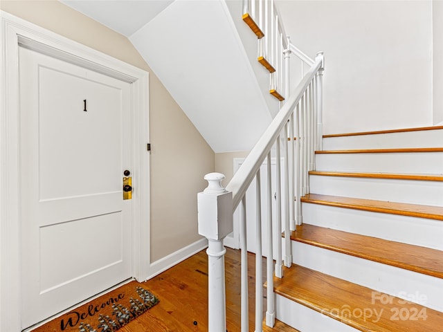 entrance foyer with vaulted ceiling and hardwood / wood-style flooring