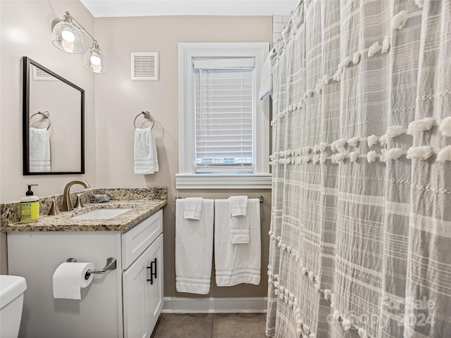 bathroom featuring toilet, vanity, and tile patterned floors