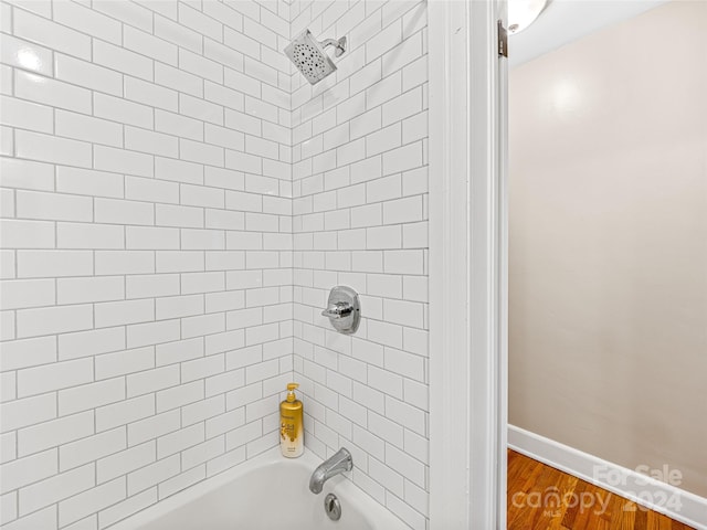 bathroom featuring hardwood / wood-style flooring and tiled shower / bath