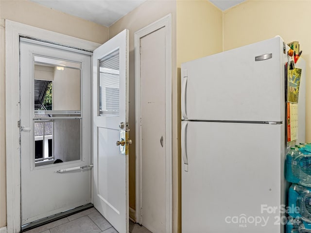 interior space featuring light tile patterned floors and white refrigerator