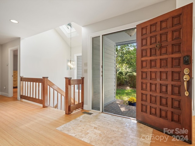 foyer with a skylight and hardwood / wood-style flooring